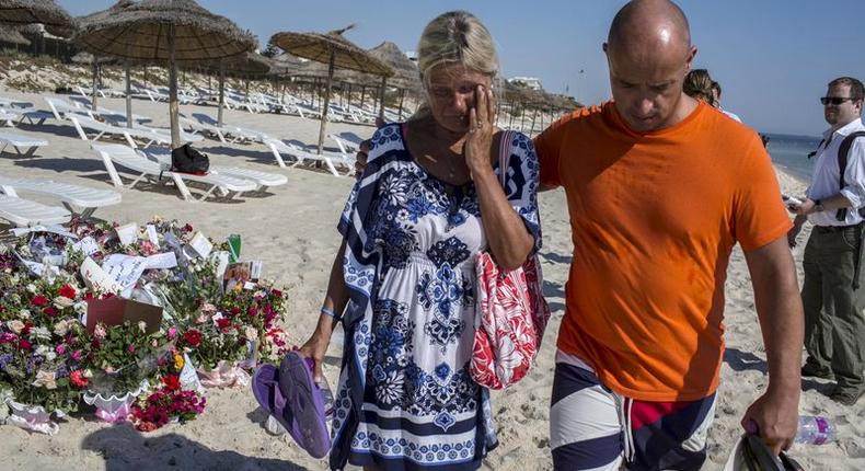 A tourist reacts after paying tribute at a makeshift memorial at the beachside of the Imperial Marhaba resort, which was attacked by a gunman in Sousse, Tunisia, June 29, 2015. REUTERS/Zohra Bensemra