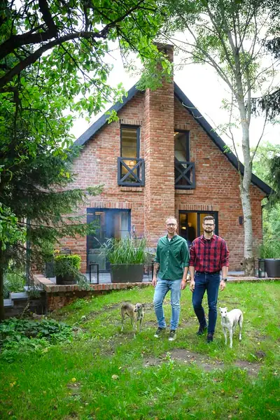 Marek Bernatowicz y Tomasz Motylewski frente a la casa reformada