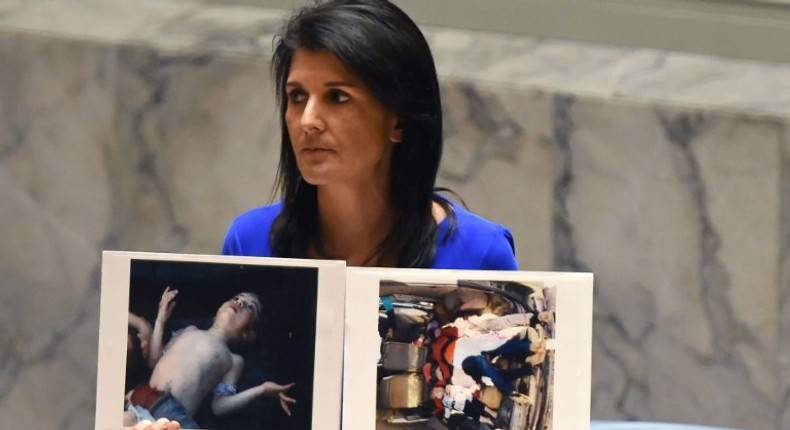 US Ambassador to the UN Nikki Haley holds photos of victims as the UN Security Council meets in an emergency session in April about a suspected deadly chemical attack that killed civilians, including children, in Syria