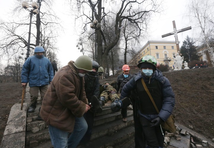 Walczący transportują rannego opozycjonistę. Fot. EPA/MAXIM SHIPENKOV/ PAP/EPA