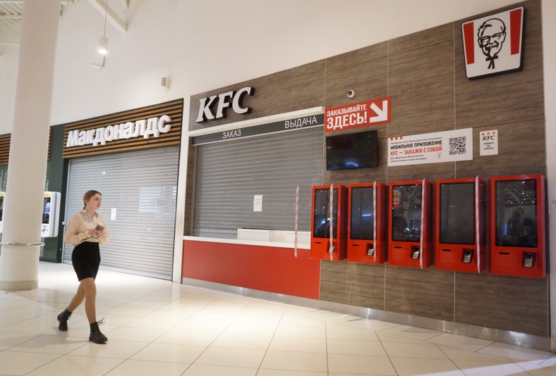 Kobieta spaceruje w pobliżu zamkniętych restauracji KFC i McDonald's w Moskwie, 16 kwietnia 2022 r., w Moskwie