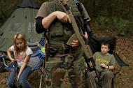 Member of the North Florida Survival Group wait with their rifles before heading out to perform enem