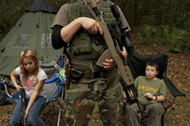 Member of the North Florida Survival Group wait with their rifles before heading out to perform enem