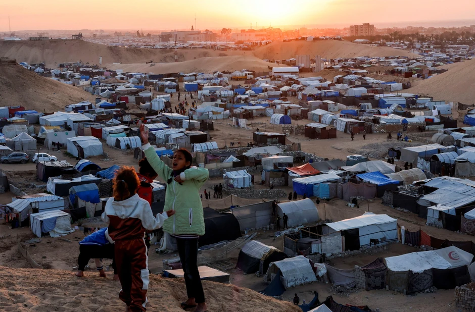 Raseljena palestinska deca na uzbrdici ispod koje je izbegličko šatorsko naselje | Foto: Reuters