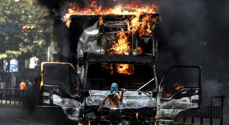 A truck set ablaze by opposition activists blocks an avenue during a protest in Caracas
