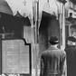 Germans pass by the smashed windows of a Jewish-owned shop. The aftermath of Kristallnacht (Night of