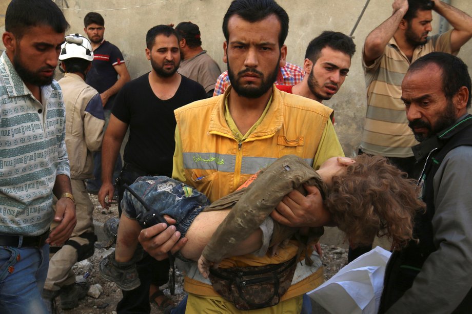 A medic holds a dead child after airstrikes in the rebel held Karam Houmid neighborhood in Aleppo, Syria October 4, 2016.