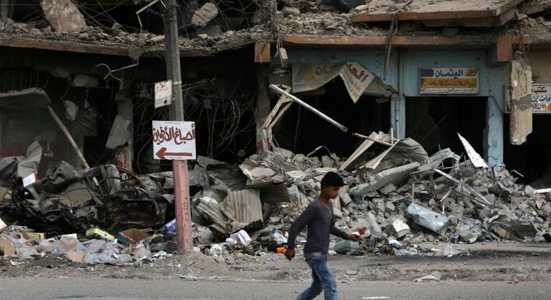 A boy walks along a damaged street in west Mosul on July 13, 2017, a few days after the government's announcement of the liberation of the city from the Islamic State group