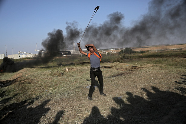 Palestyński protestant rzucający kamieniem.