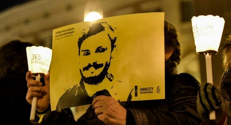 Activists of human rights organization Amnesty International hold a picture of Giulio Regeni and candles as they take part in a demonstration in front of Montecitorio, the Italian Parliament, in Rome on January 25, 2017