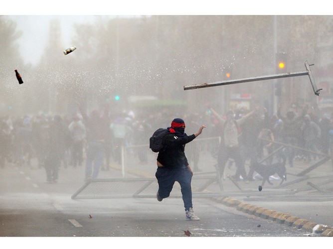 Chilijski student w starciu z policją podczas protestu przeciwko wysokim kosztom edukacji. Santiago, sierpień 2011