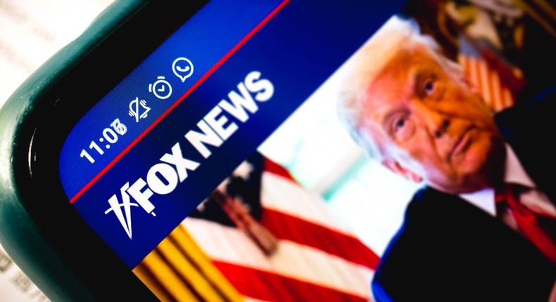 A close-up of the Fox News Channel website with a picture of President Donald Trump displayed on a smartphone.