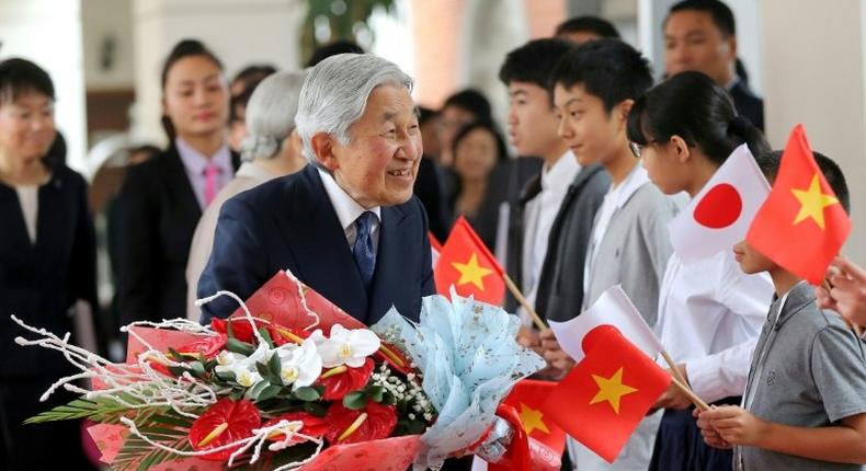 Emperor Akihito (centre) greets people after arriving at a hotel in Hanoi on February 28, 2017