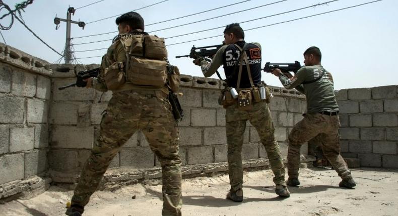 Iraqi forces fire from a position on the rooftop of a building in Mosul's northwestern al-Haramat neighbourhood on May 11, 2017 during their ongoing offensive to retake the area from Islamic State (IS) group fighters