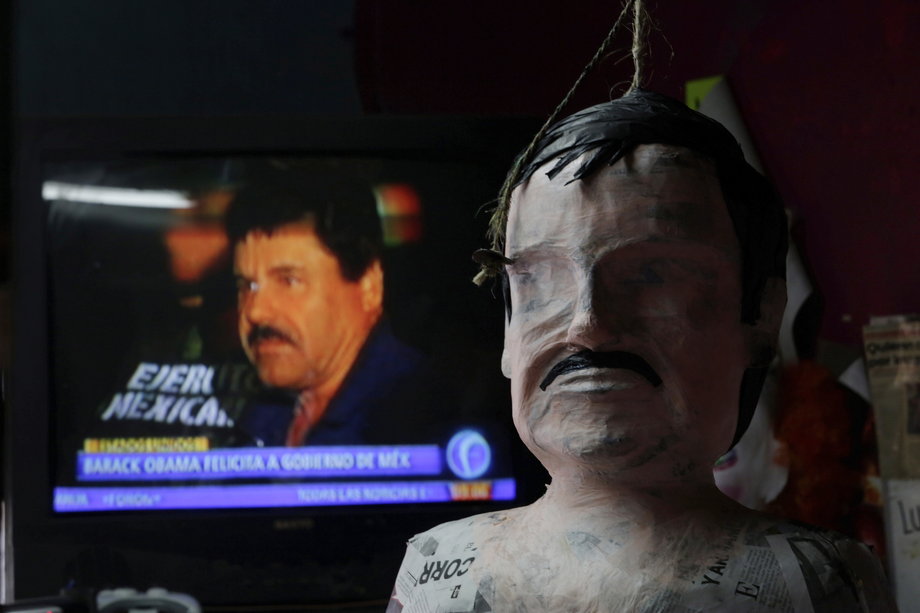 A piñata in progress depicting the drug lord Joaquín "El Chapo" Guzmán in front of a TV showing a news bulletin of him, at a workshop in Reynosa, Tamaulipas, Mexico, on January 13, 2016.