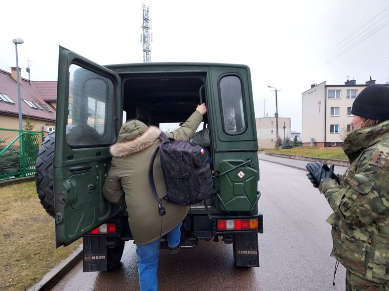 Dziennikarze w strefie zamkniętej są wożeni samochodami służb, Szudziałowo, woj. podlaskie, 16.12.2021.