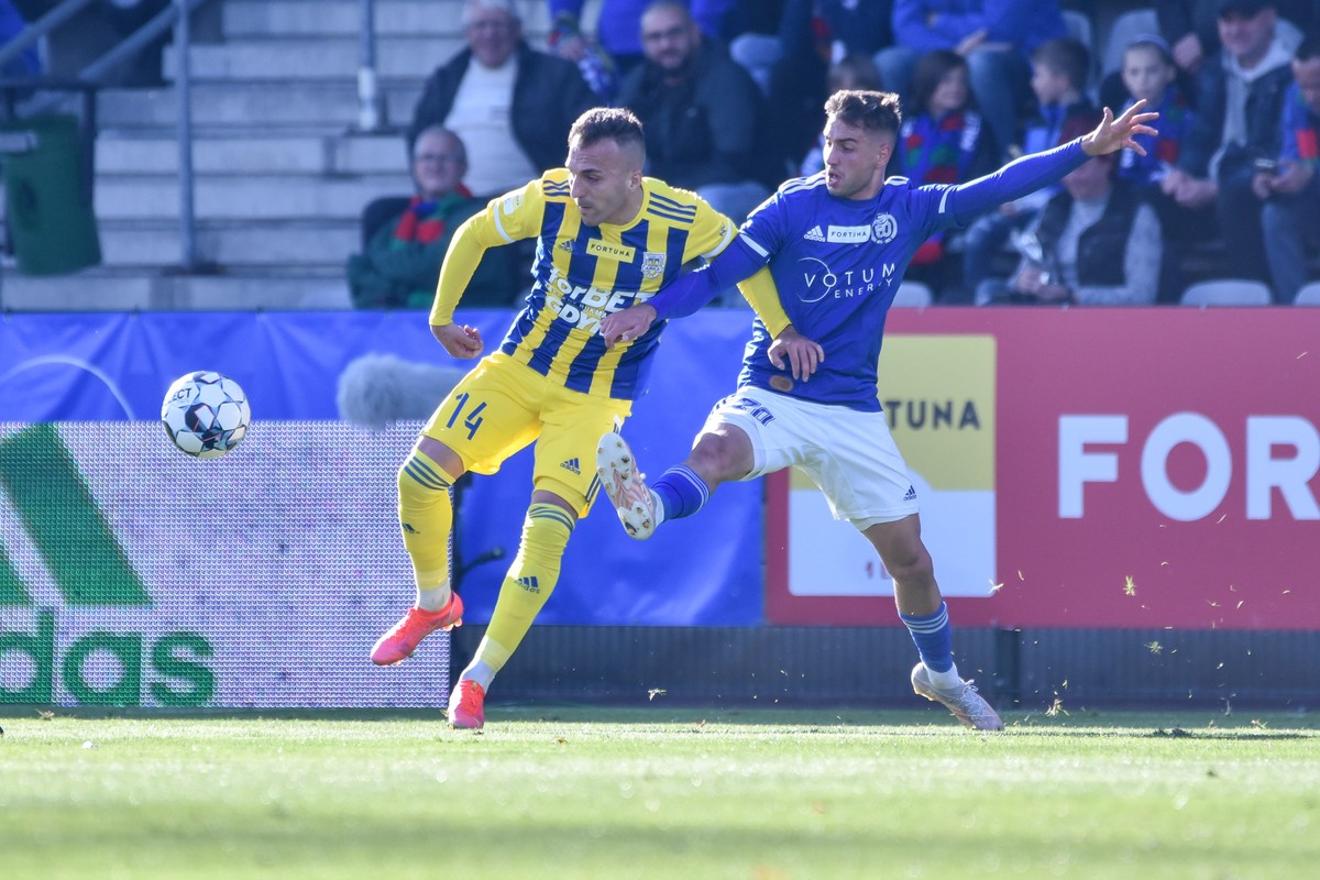 Piłkarz Arki Gdynia Luis Valcare Vidal (L) w starciu z zawodnikiem Miedzi Legnica Maciejem Śliwą (P)