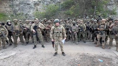 Founder of Wagner private mercenary group Yevgeny Prigozhin makes a statement as he stand next to Wagner fighters in an undisclosed location. [REUTERS]
