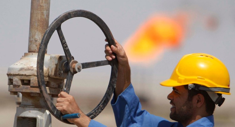 A worker adjusts a pipe at the Nassiriya oilfield in Nassiriya, Iraq.