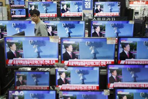 A sales assistant watches TV sets broadcasting a news report on North Korea's nuclear test, in Seoul