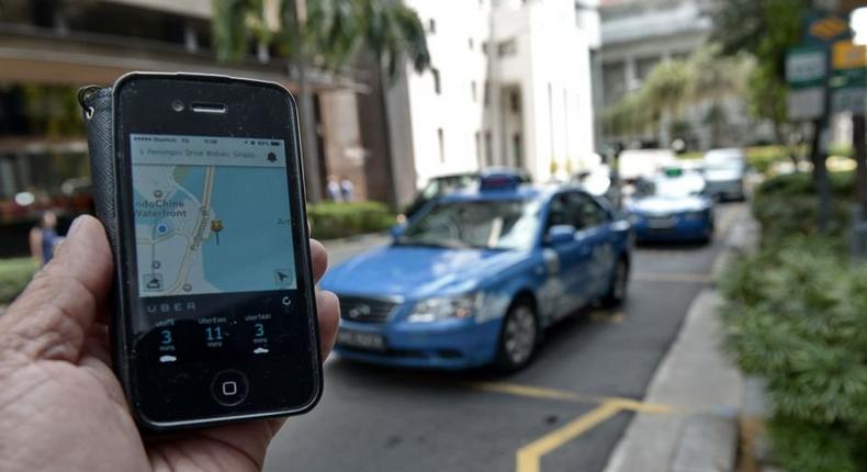 TO GO WITH STORY Singapore-SEAsia-transport-Internet-taxi-Malaysia-Indonesia,FOCUS by Bhavan Jaipragas This photograph taken on October 10, 2014 shows a smartphone displaying the Uber app of the timing and availability of taxis within the area at Raffles place financial district in Singapore. Southeast Asia's notorious taxi market is undergoing a shakeout as Uber and homegrown mobile booking applications gain popularity in a region that has long endured inefficient cartels and price-gouging drivers. AFP PHOTO/ROSLAN RAHMAN (Photo by Roslan RAHMAN / AFP) (Photo credit should read ROSLAN RAHMAN/AFP/Getty Images)