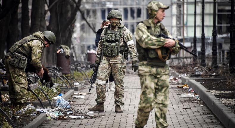 Russian soldiers walks along a street in Mariupol on April 12, 2022.