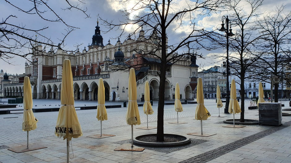 Kraków. Zwinięte parasole na Rynku przypominają chochoły z Wesela Stanisława Wyspiańskiego