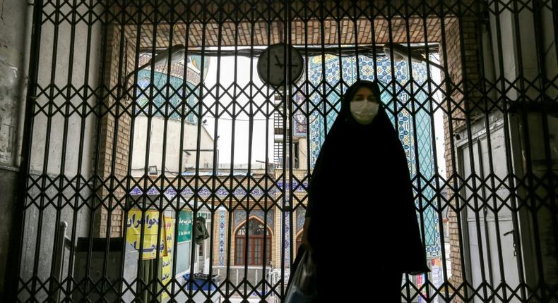 A woman walks past the closed gate of the Imamzadeh Saleh mosque in the Iranian capital Tehran on April 25. On Monday Iran reopened some places of worship in parts of the country deemed at low risk from the coronavirus