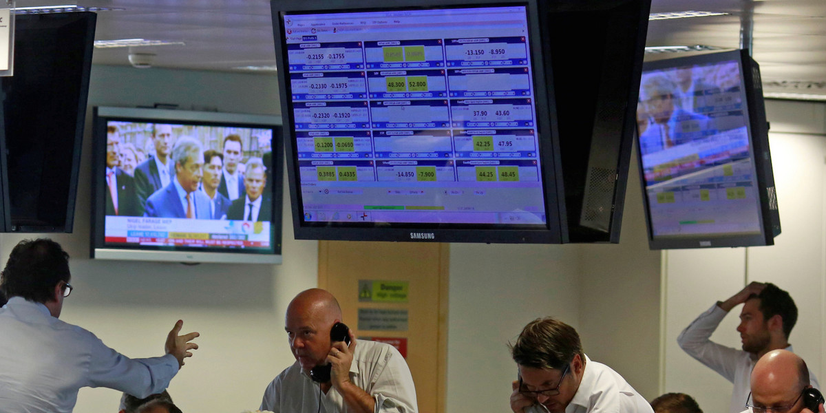 UKIP leader Nigel Farage is seen on TV as traders from BGC, a global brokerage company in London's Canary Wharf financial centre, react during trading on June 24, 2016, after Britain voted to leave the EU.