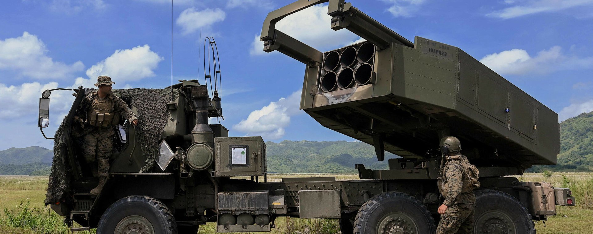 Oficerowie amerykańskiej piechoty morskiej stoją obok systemu M142 (HIMARS) podczas ćwiczeń. Zdjęcie ilustracyjne. 