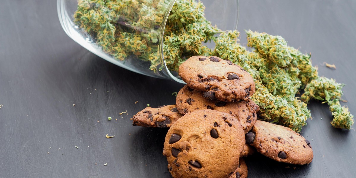 Cookies with cannabis and buds of marijuana on the table. Copy Space Concept of cooking with cannabis herb. Treatment of medical marijuana for use in food, On a black background