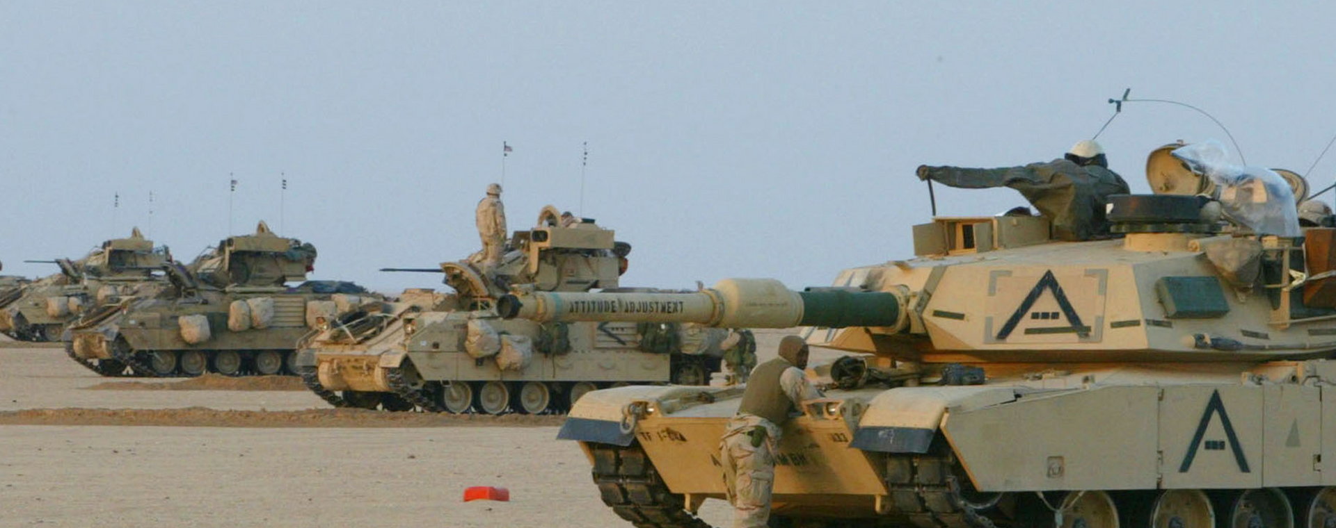 Pojazdy M1A1 Abrams i Bradley ustawiają się w szeregu, przygotowując się do przemarszu przez pustynię 18 grudnia 2002 r. w pobliżu granicy z Irakiem w Kuwejcie. Są częścią Pancernej Grupy Zadaniowej 1-64, uczestniczącej w operacji Pustynna Wiosna w pobliżu granicy z Irakiem.