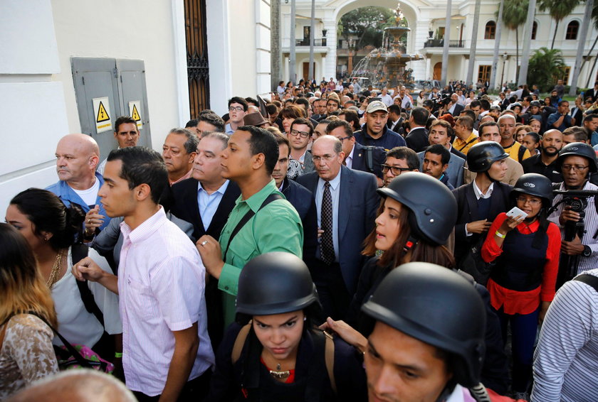 An injured government supporter is taken away by security forces after he and a group of fellow gove