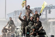 Syrian Democratic Forces (SDF) fighters ride atop of military vehicles as they celebrate victory in Raqqa