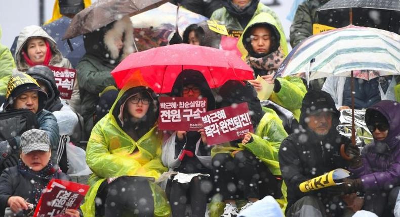 Protesters hold banners calling for the resignation of South Korean President Park Geun-Hye in central Seoul on November 26, 2016