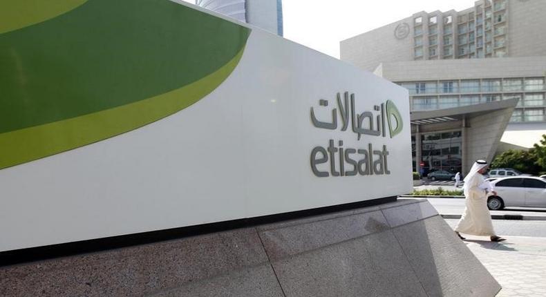 A man walks past a sign at the headquarters of telecommunications company Etisalat in Dubai October 25, 2011. REUTERS/Jumana El Heloueh