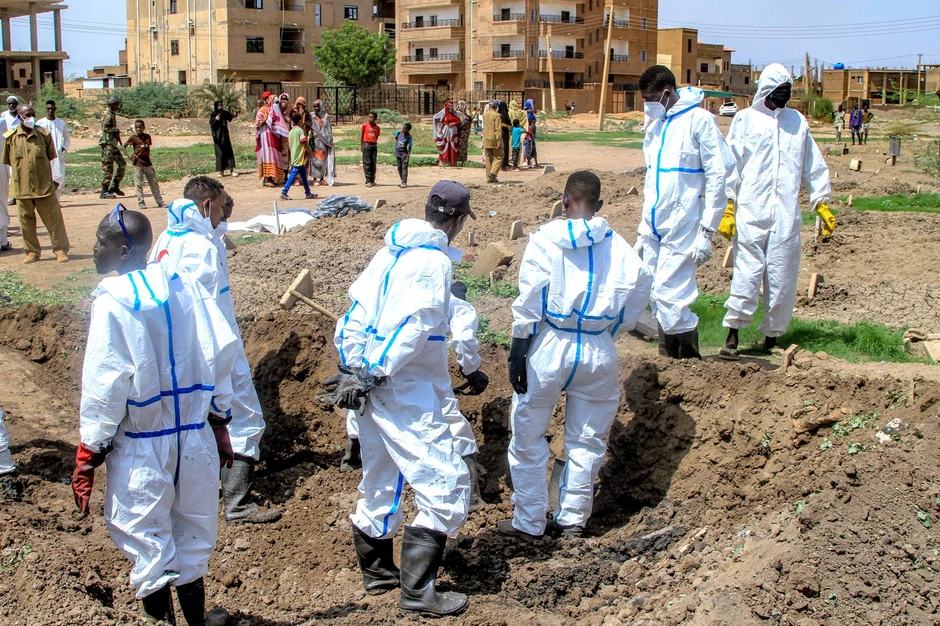 Pripadnici sudanskog Crvenog polumeseca iskopavaju posmrtne ostatke iz improvizovane grobnice radi sahrane na lokalnom groblju u Kartumu 2. avgusta 2025. 