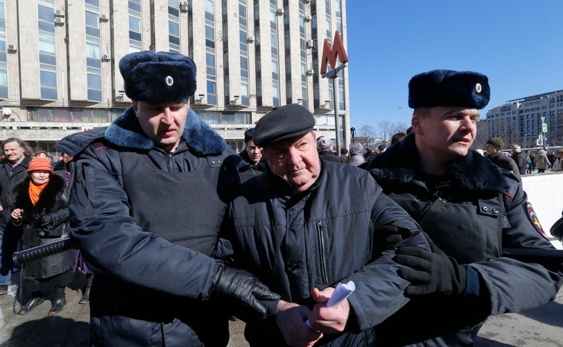 Milicjanci zatrzymują demonstrantów