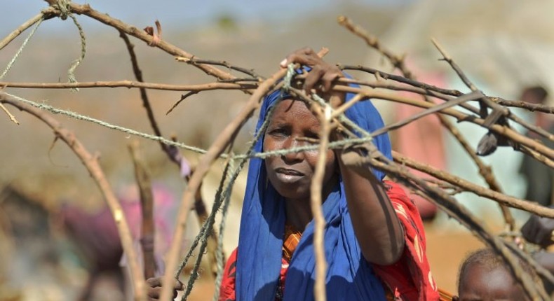 A woman builds a shelter at a makeshift camp on the outskirts of Baidoa, in the southwestern Bay region of Somalia