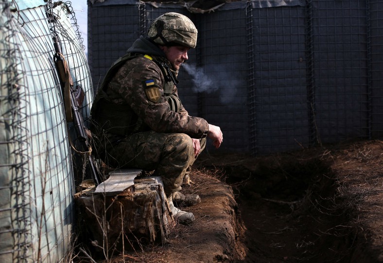 Ukraiński żołnierz w okopach w okolicach Ługańska. Zdjęcie wykonane dzień po tym, jak Władimir Putin uznał niepodległość tzw. ługańskiej republiki ludowej