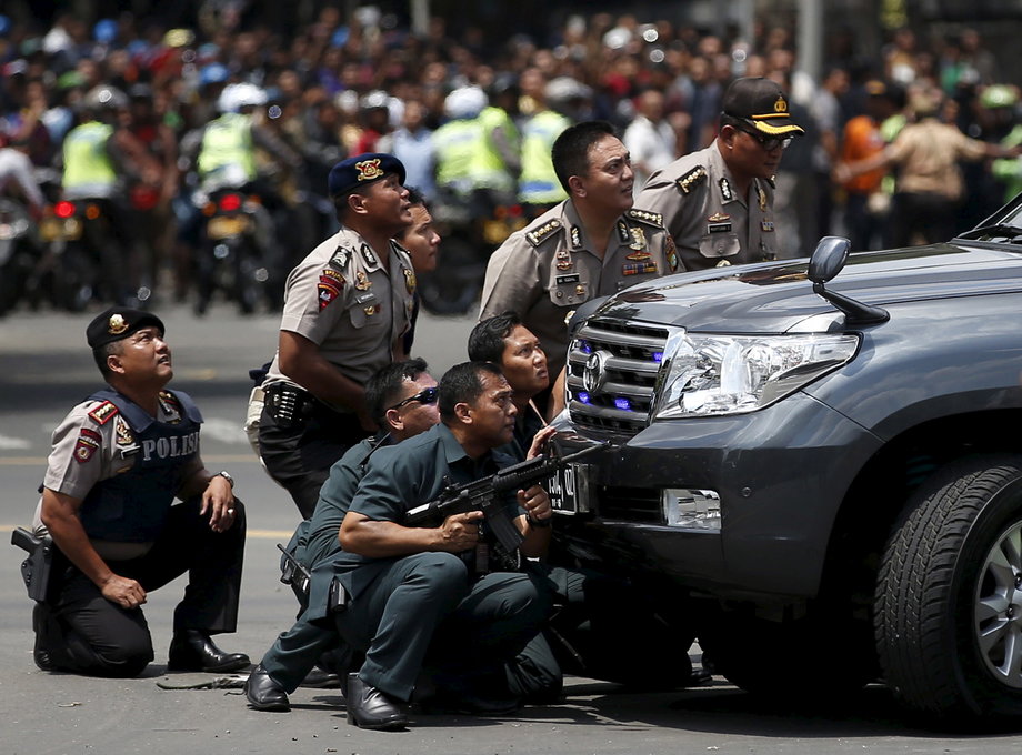 Police officers react near the site of a blast in Jakarta, Indonesia, January 14, 2016. Several explosions went off and gunfire broke out in the center of the Indonesian capital and police said they suspected a suicide bomber was responsible for at least one the blasts.