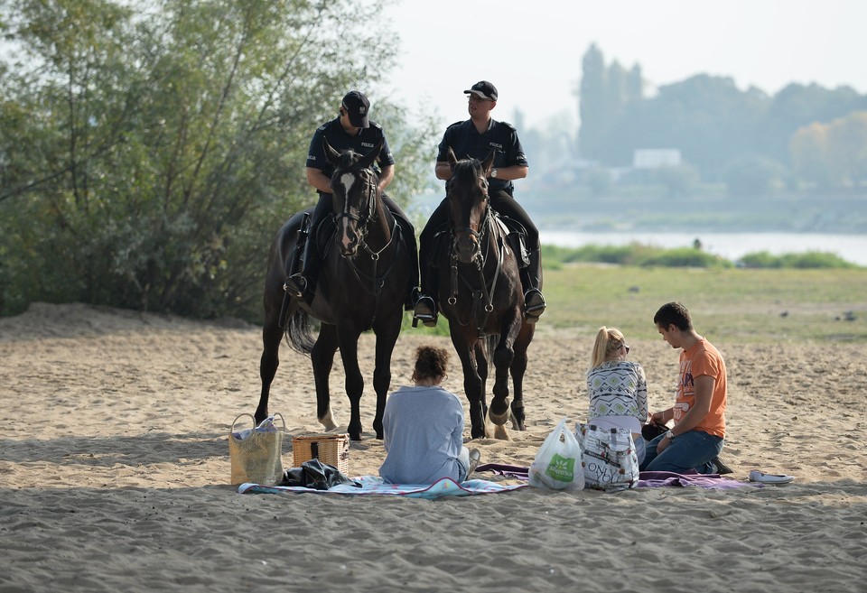 Patrol konny policji podczas kontroli na plaży przy moście Poniatowskiego, po praskiej stronie Wisły.