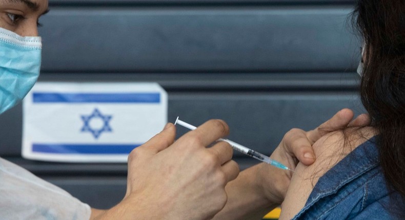 An Israeli receives a coronavirus vaccine from medical staff at a COVID-19 vaccination center in Tel Aviv, Israel, Wednesday, Jan. 6, 2021.
