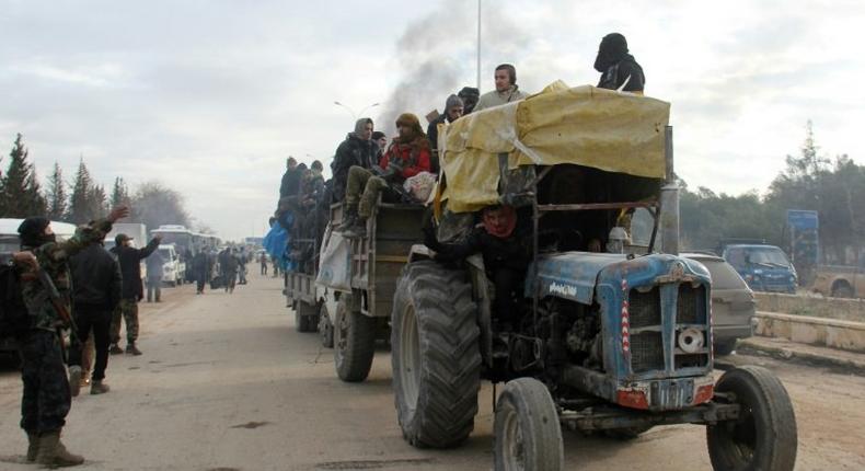 A tractor carrying people evacuated from rebel-held neighbourhoods of Aleppo arrives in opposition-controlled Khan al-Assal on December 16, 2016