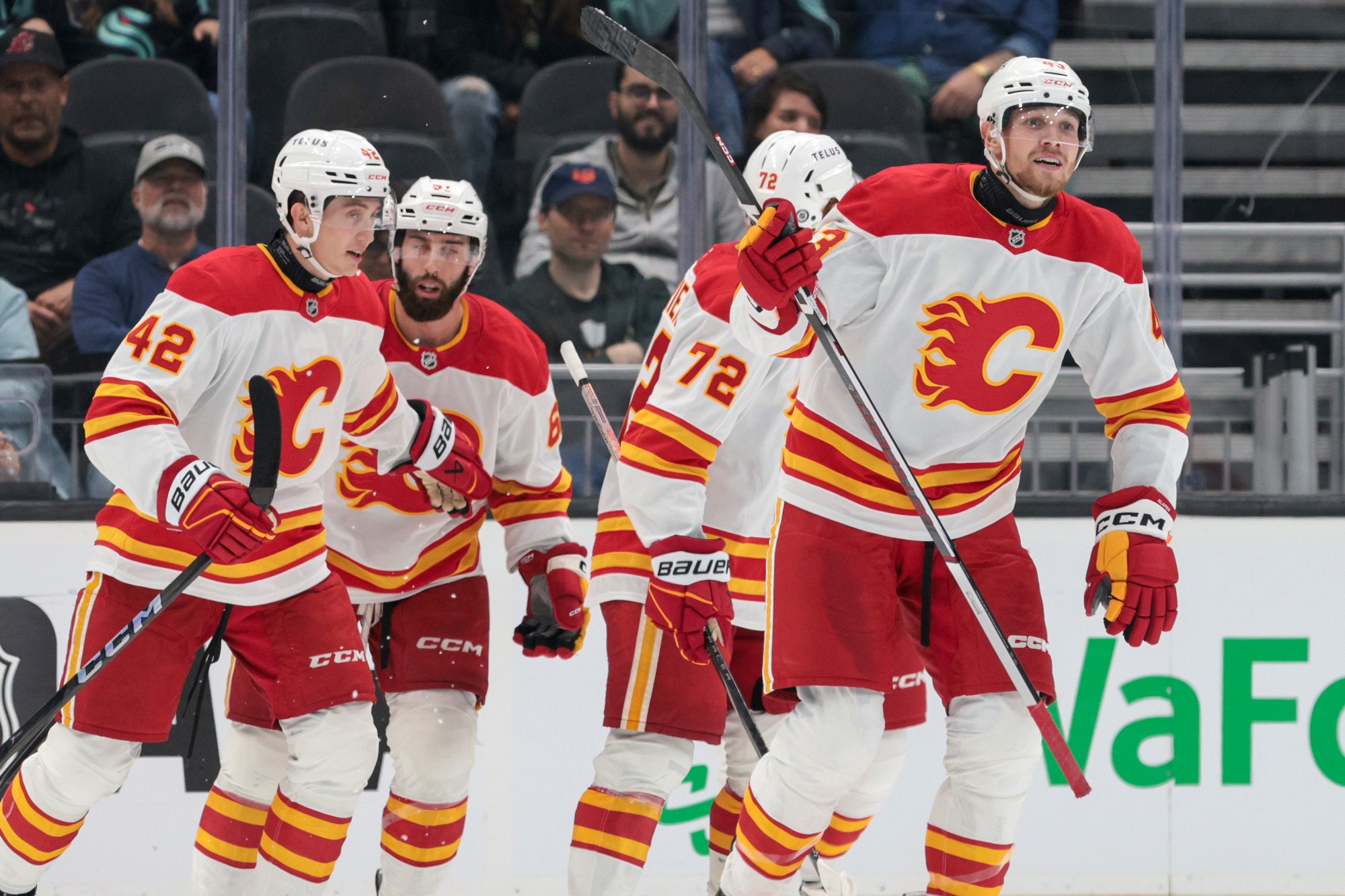 Hokejista Adam Klapka (vpravo) z Calgary Flames sa raduje z gólu so spoluhráčmi Jeremiem Poirierom (72), Clarkom Bishopom (druhý vľavo) a slovenským hokejistom Samuelom Honzekom.