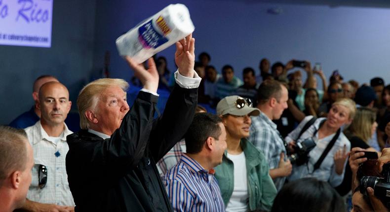 Former President Donald Trump tosses a paper towel roll into a crowd of people at Calvary Chapel in Guaynabo, Puerto Rico on Oct. 3, 2017.