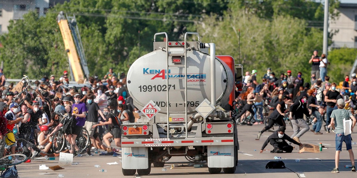 Protesters scale a truck that was driven into a rally