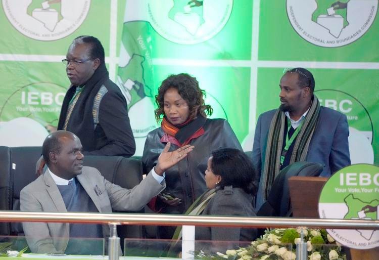 Electoral Commission (IEBC) Chairman, Wafula Chebukati, left, chats with IEBC commissioners, at the National Tallying Centre in Bomas of Kenya,