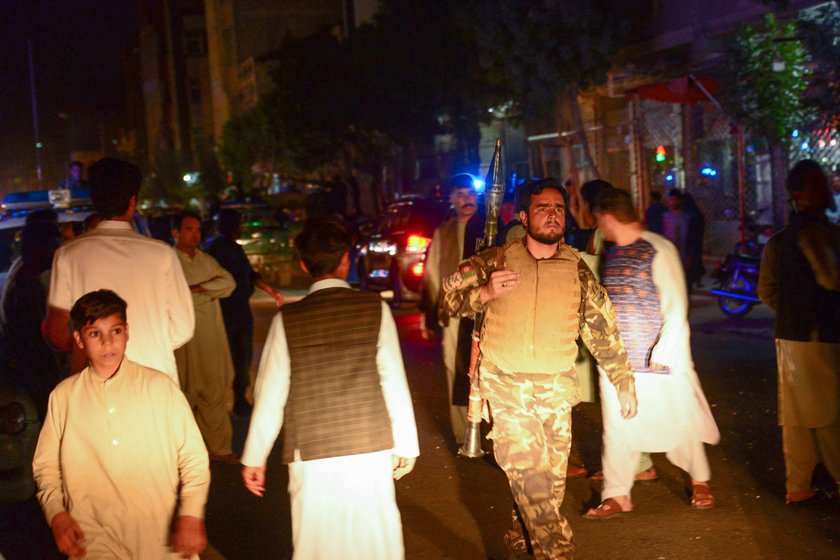 Afghan policemen and relatives inspect at the site of a suicide attack in Herat, Afghanistan