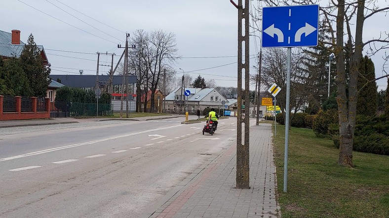 Pracownik gminy na skuterze z narzędziami do czyszczenia.